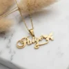 Dainty 18K gold plated stainless steel custom name necklace with the name Paige on it and a butterfly, resting on white marble.