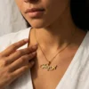 Woman wearing a gold plated custom charm necklace with the name Paige, it's a durable stainless steel necklace