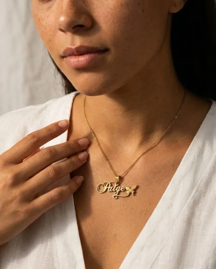 Woman wearing a gold plated custom charm necklace with the name Paige, it's a durable stainless steel necklace